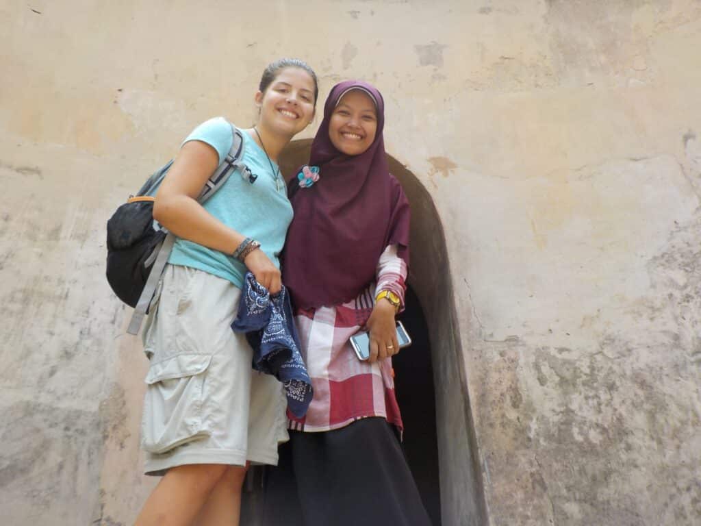 people smiling in front of wall