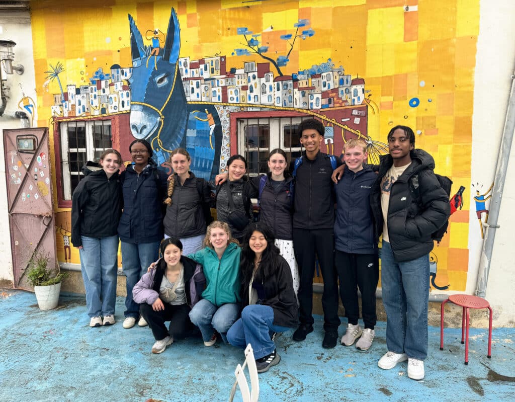 People posing in front of donkey mural