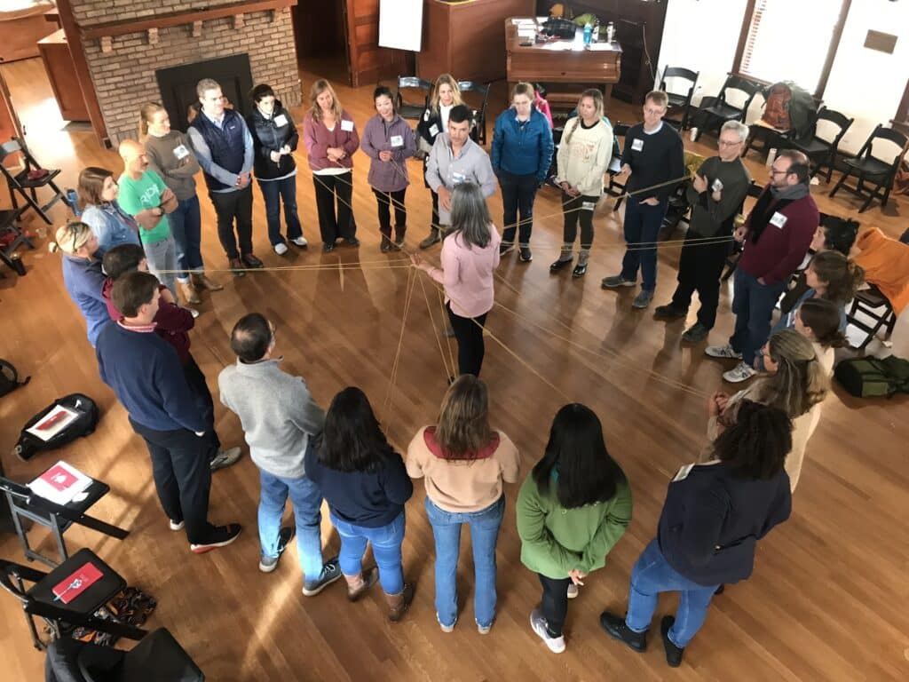 group in circle holding string for activity