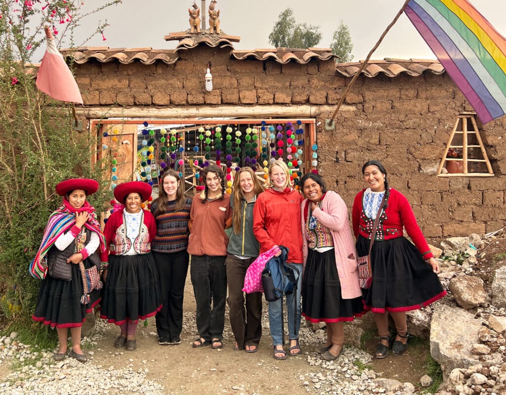 group in font of mud brick building