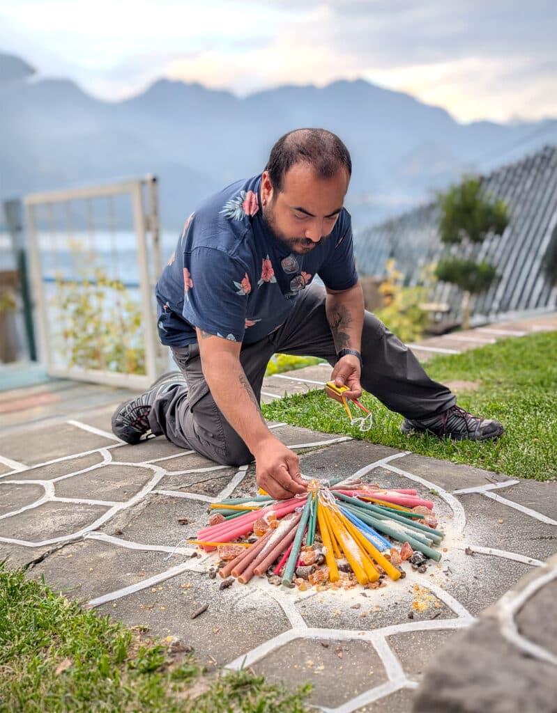man stacking colorful candles for ceremony