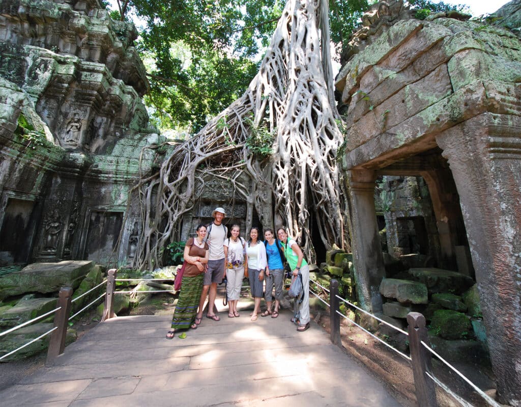 group posing in front of Cambodian ruins