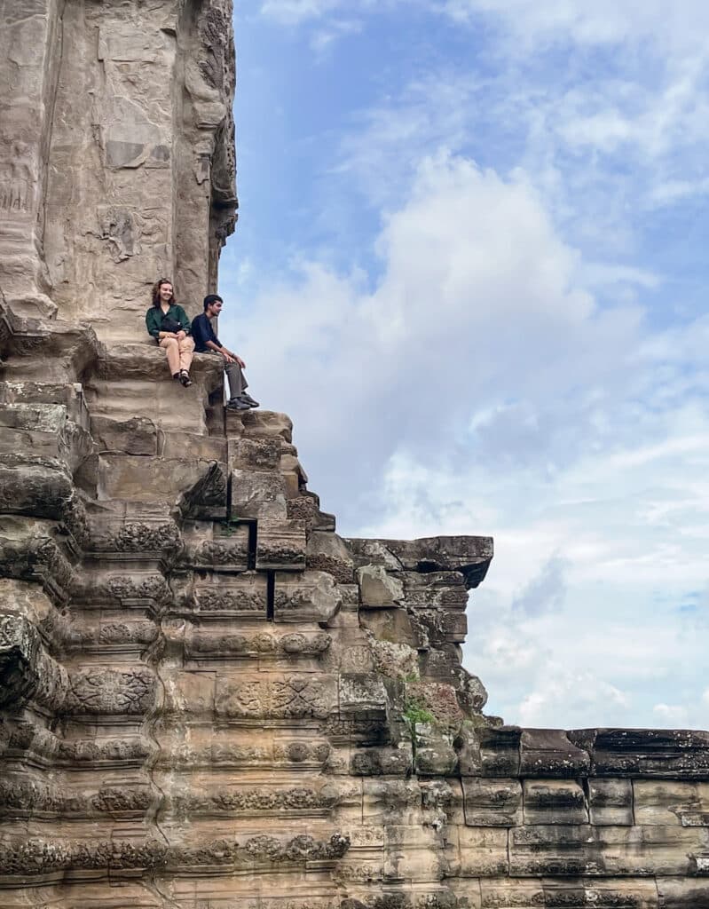 people sitting on steps of a ruin
