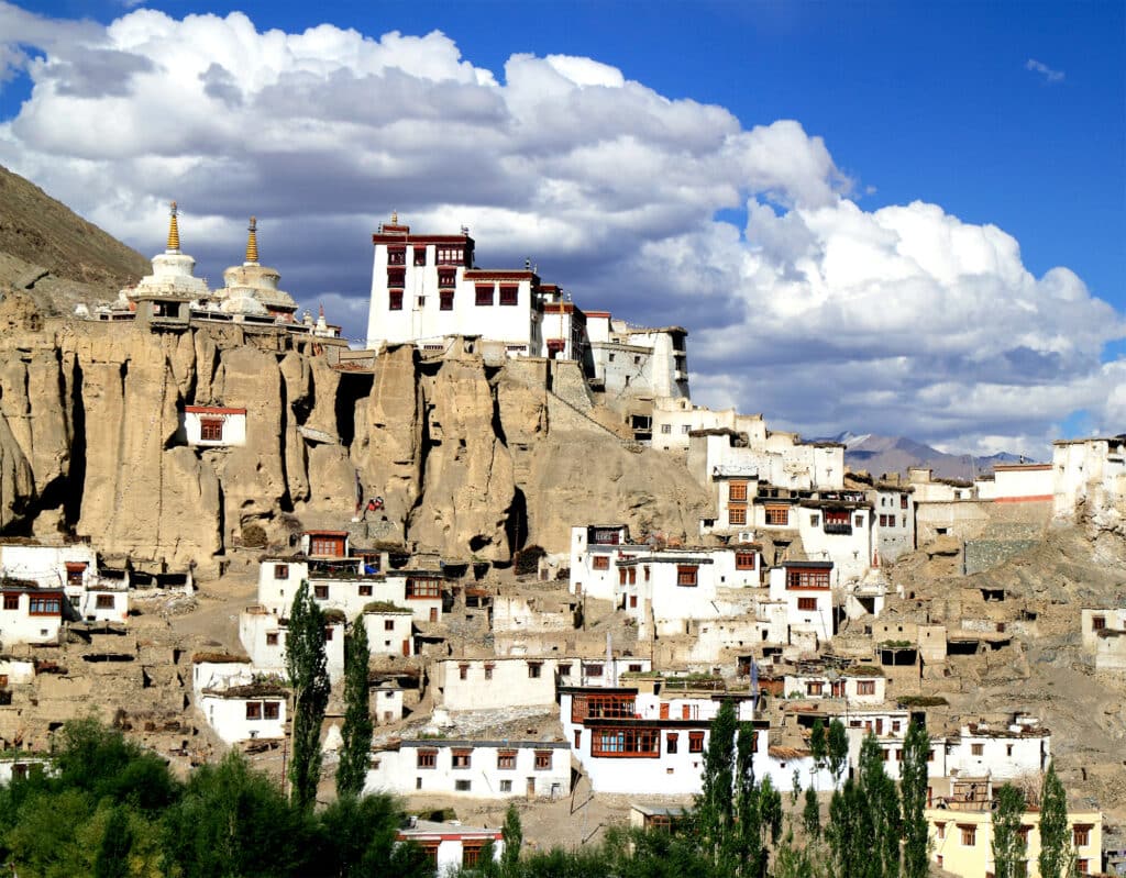white buildings built into brown cliffs