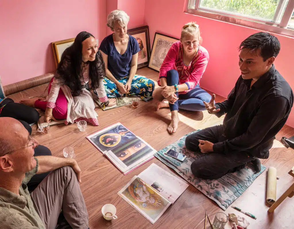 Group sitting on floor looking at art portfolio