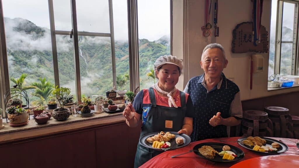people holding platters of food in front of window with plants