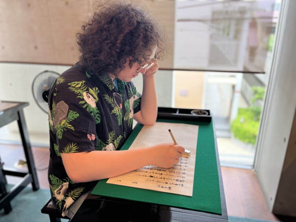 person practicing Japanese writing