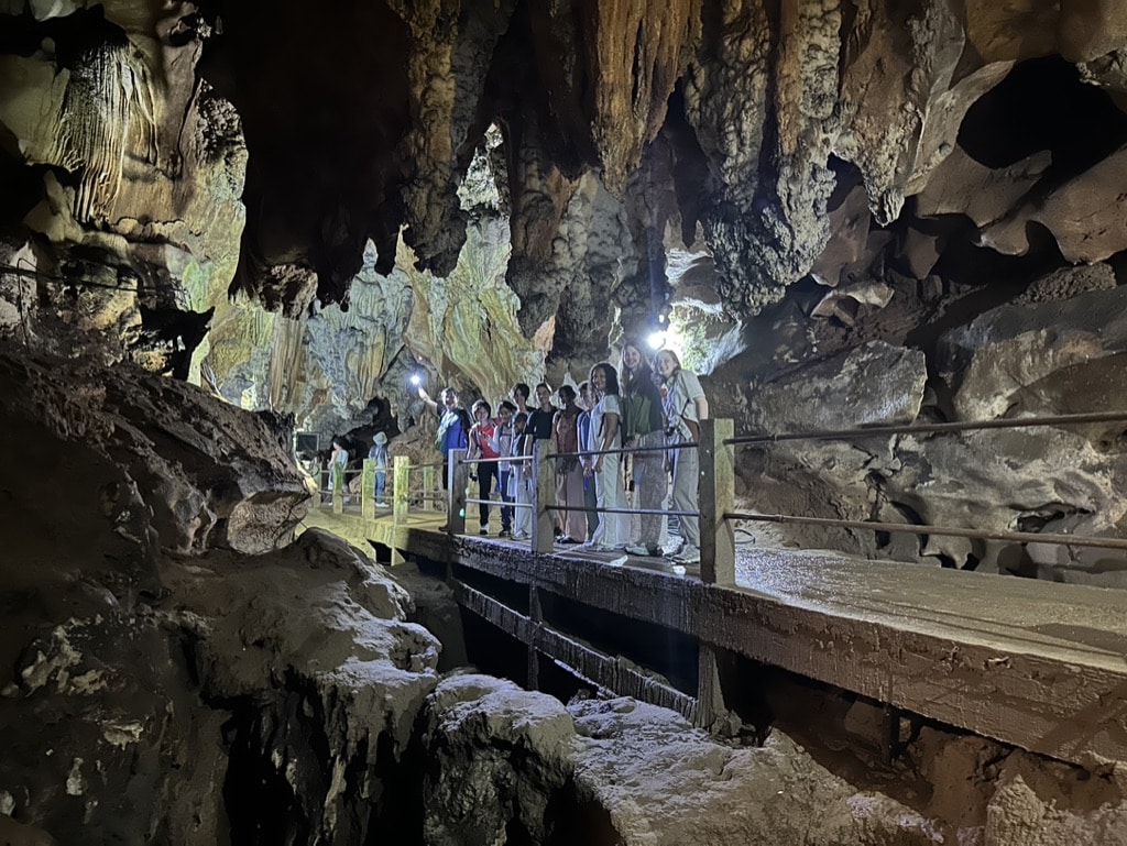 people posing on walkway in cave