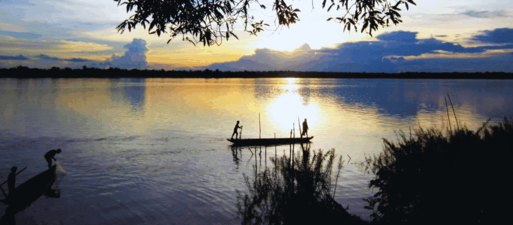 two people paddling in boat and sunset