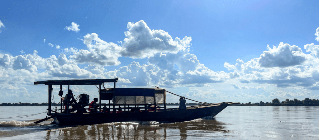 boat in water with big white clouds