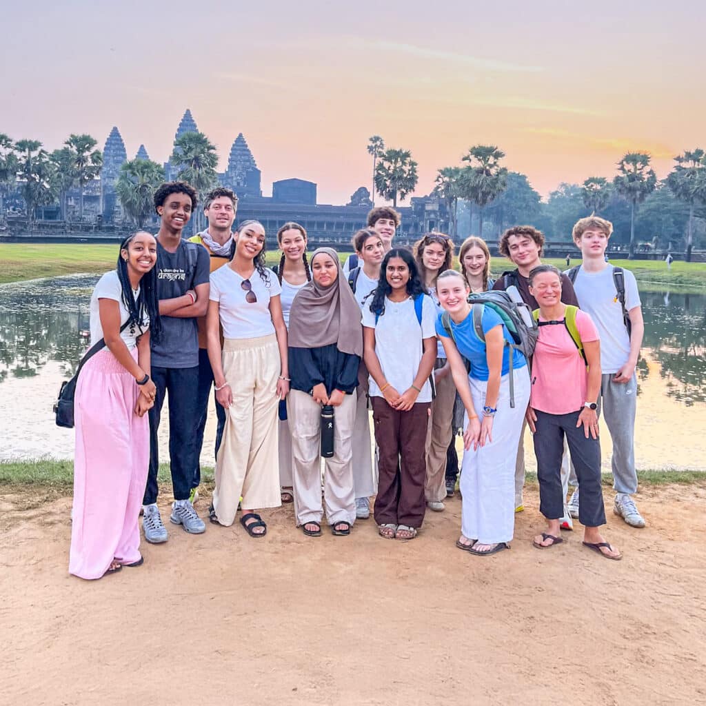group posting in front of the water with orange sky