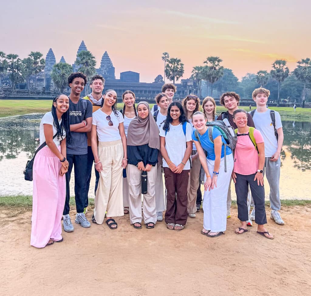 group posting in front of the water with orange sky