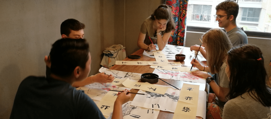 people around a table writing chinese characters
