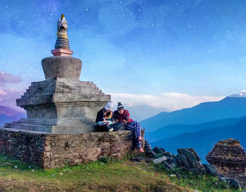 people sitting on stupa looking at book