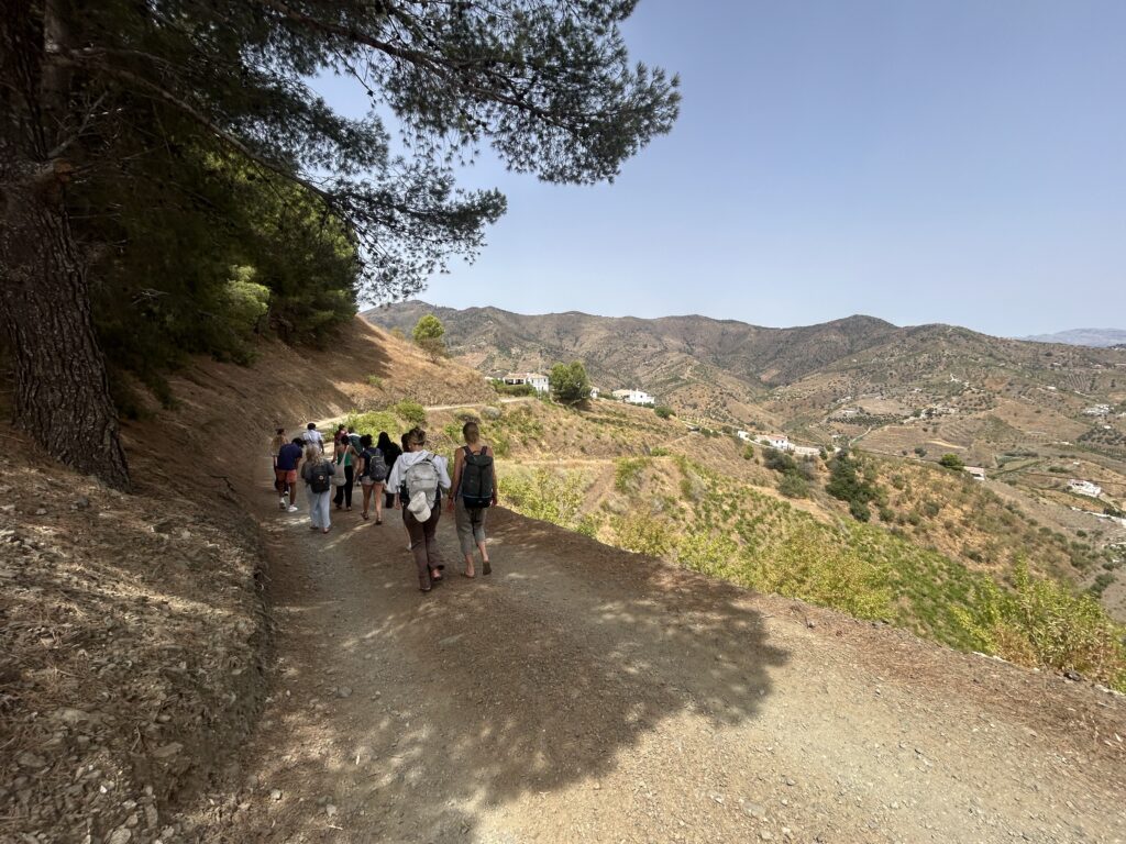 People walking on dirt road on hillside